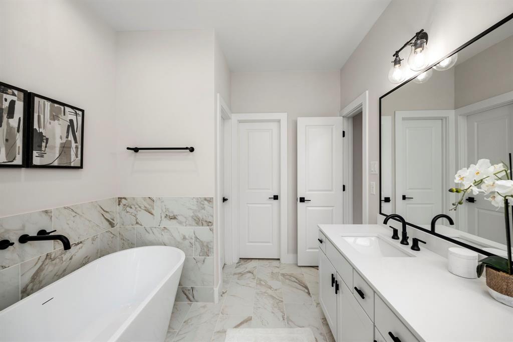 Primary Bathroom with Quartz Throughout, Freestanding Glass Shower, Large Soaking Tub, Double Vanity Sinks, and Oversized Mirror