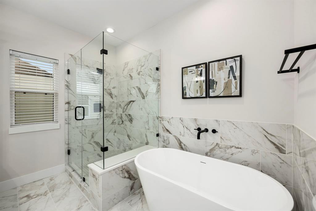 Primary Bathroom with Quartz Throughout, Freestanding Glass Shower, Large Soaking Tub, Double Vanity Sinks, and Oversized Mirror