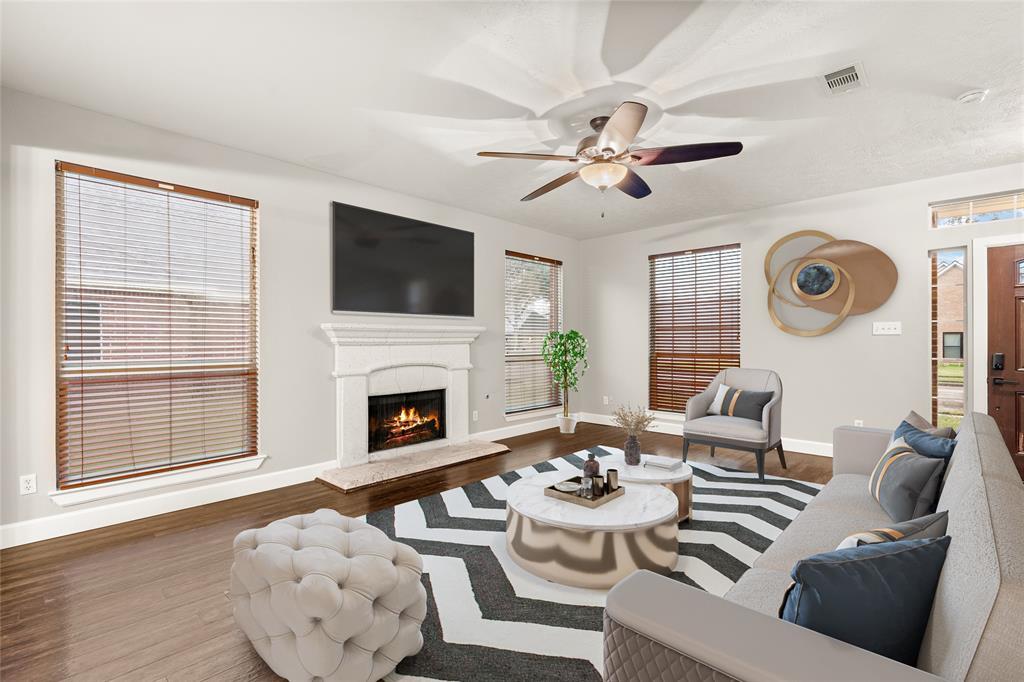 Gather the family and guests together in your lovely living room! Featuring high ceilings, dark stained ceiling fan with lighting, custom paint, gorgeous flooring, fireplace with mantel and large windows that provide plenty of natural lighting throughout the day.