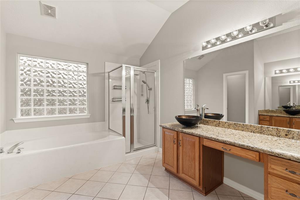 This primary bathroom is definitely move-in ready! Featuring a framed walk-in shower, separate garden tub for soaking after a long day, light stained cabinets with granite countertops, spacious closet, high ceilings, and custom paint.