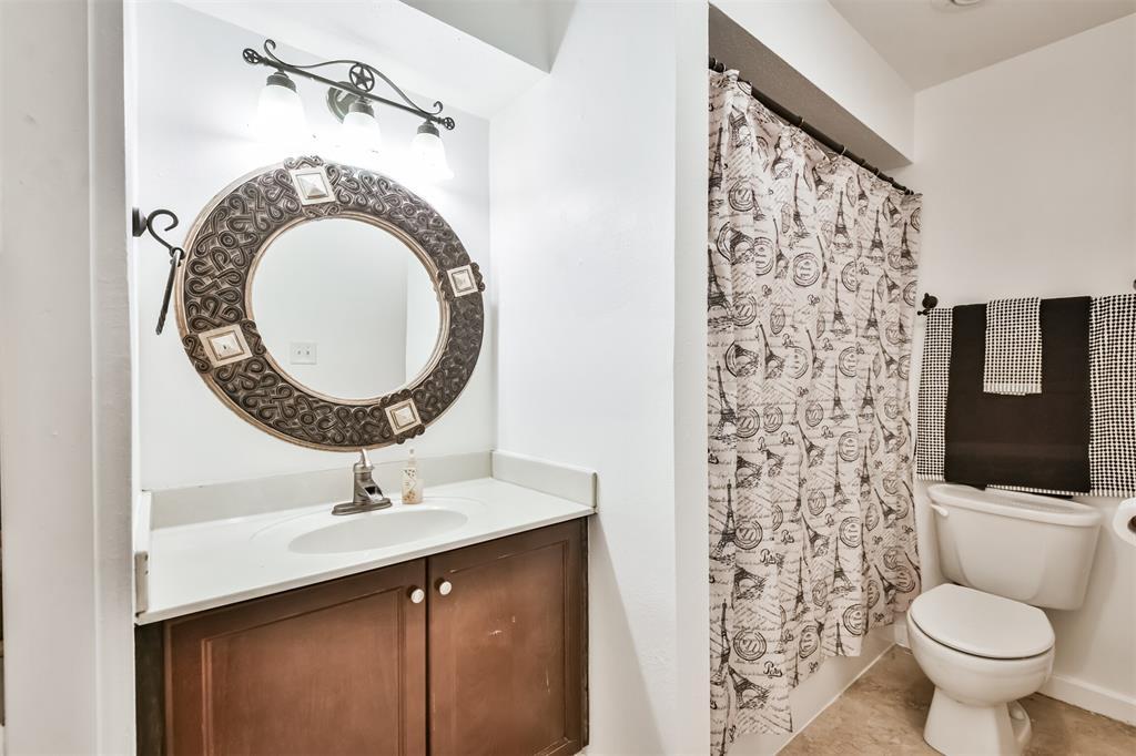 Guest bathroom is ideally located just off the living area and in between the secondary bedroom features framed mirror, tub and shower combo and additional storage just off the left of the picture.